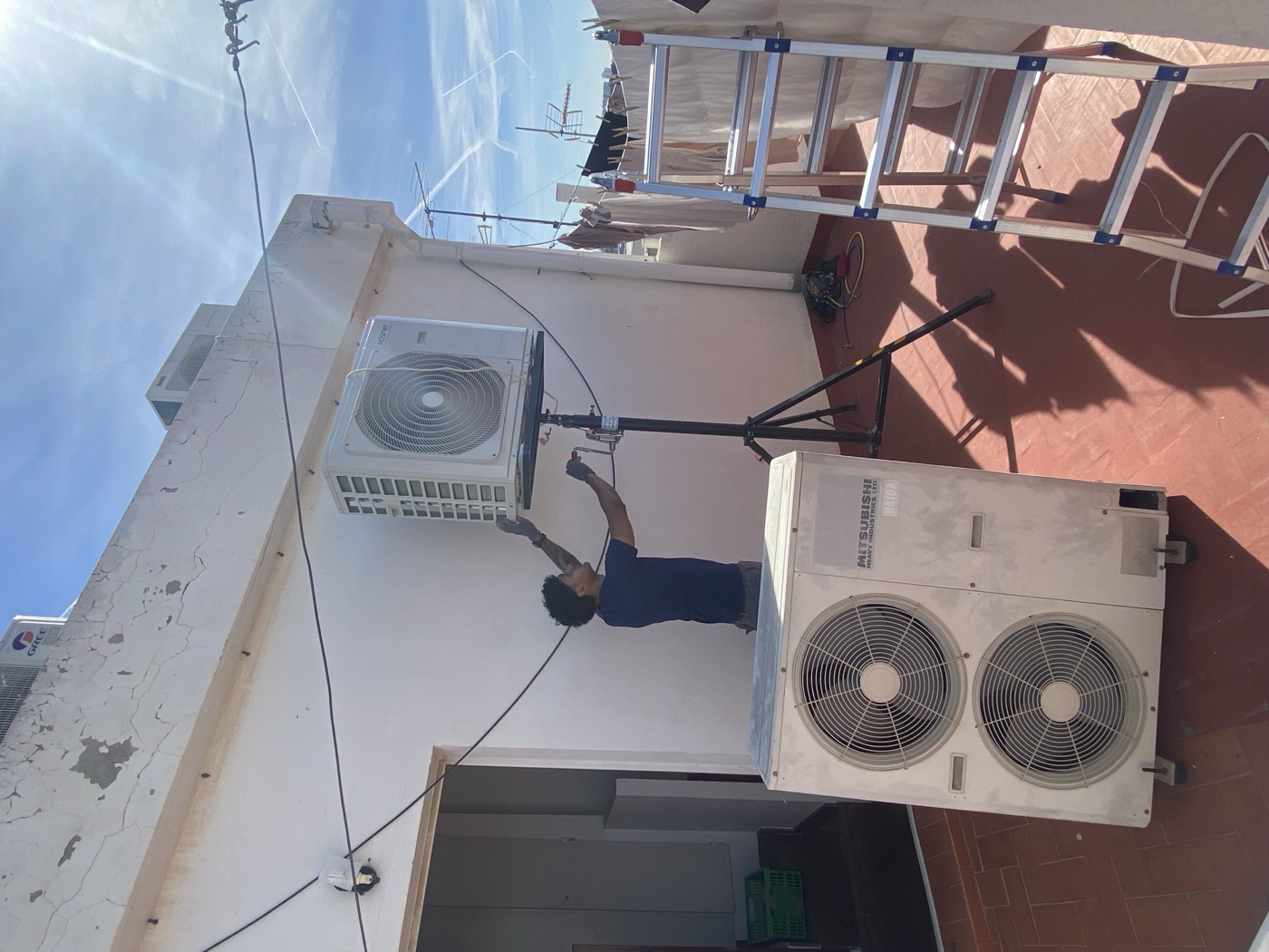 Técnico de VOLTECLIM instalando una unidad exterior de aire acondicionado en una terraza